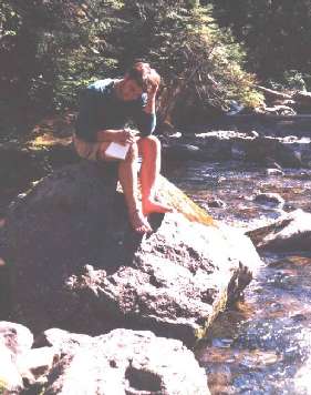 Scott contemplates his journal entry, sitting on a rock at the Nickle Creek camp. (Wonderland Trail, Mt. Rainier National Park)